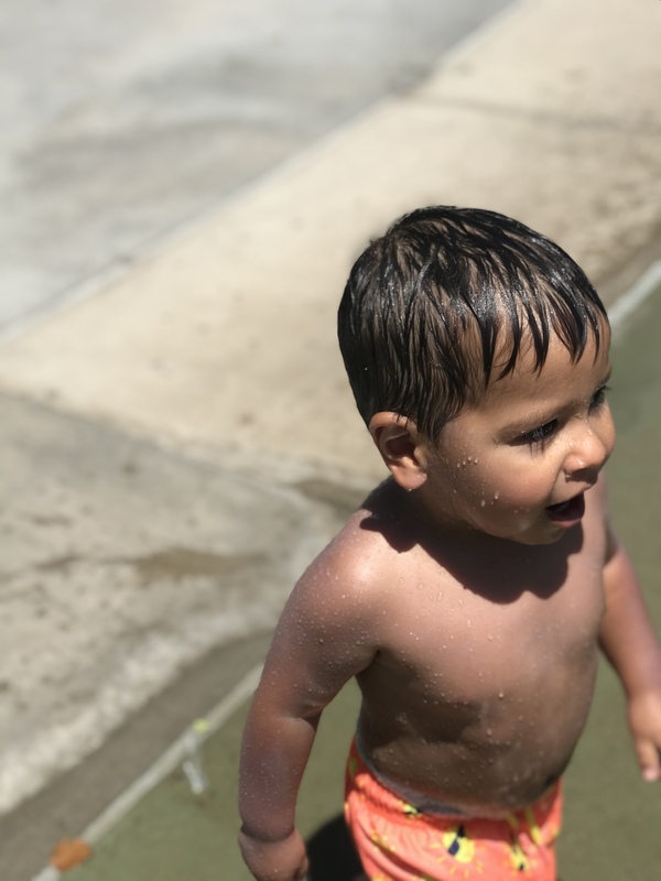 A wet child at a splash pad.