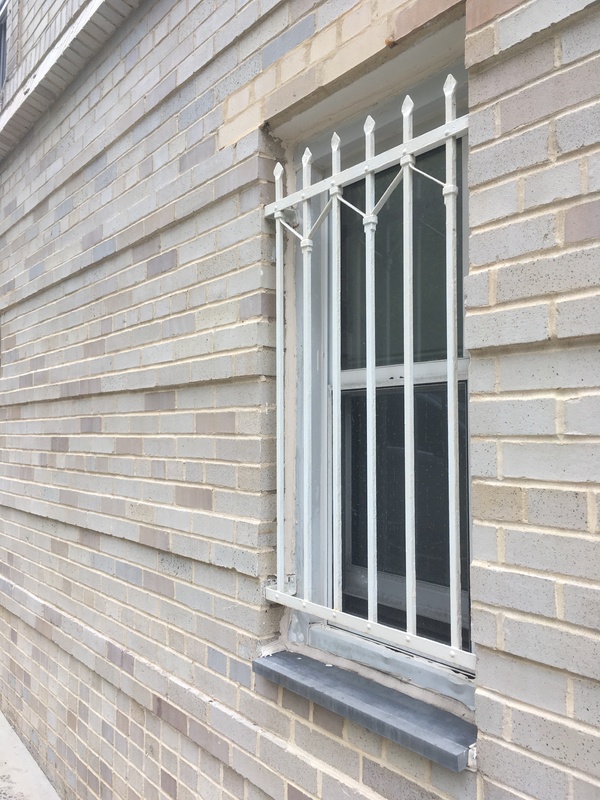 A gated window in a brick building. 