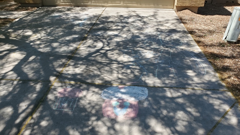 Chalk artwork in a driveway of a house. 