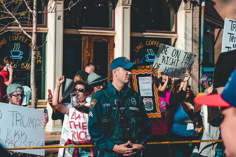 This is a picture of a police officer who is standing guard during a protest against President Donald Trump. 
