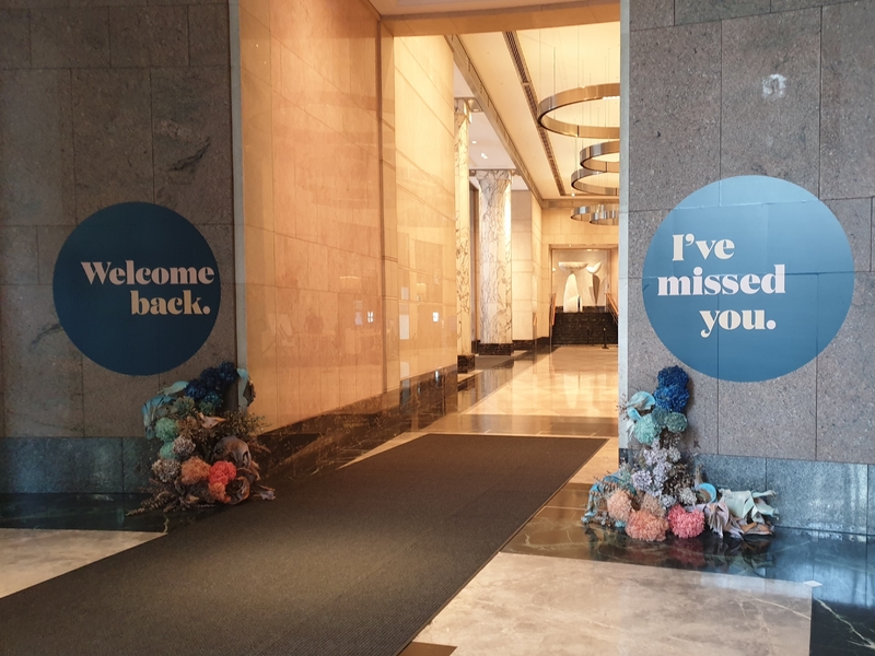 Two signs in a building welcoming workers back. The signs read Welcome Back and I've Missed You.