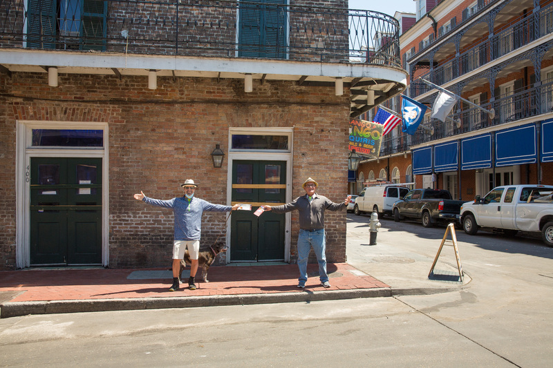 Two people spreading their arms out on the side of a street.