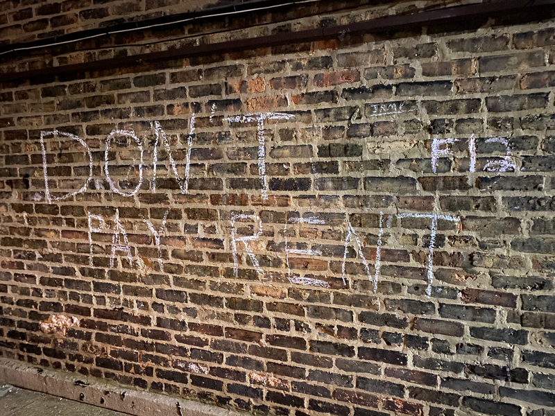 A chalk message on a brick wall. 