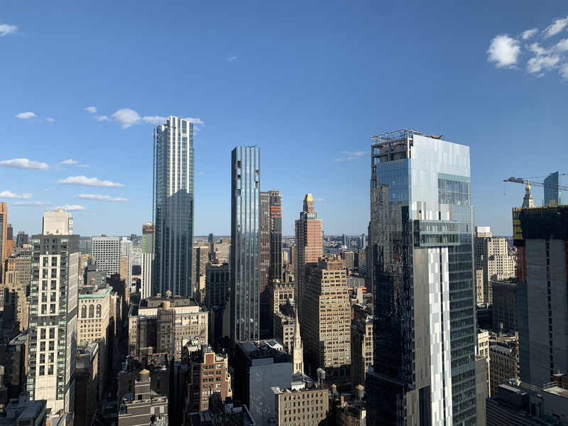 A photo taken within a city shows skyscrapers and other buildings around.