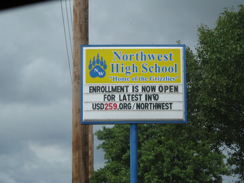 A high school sign reading "Enrollment is Now Open. For Latest Info USD259.org/northwest".