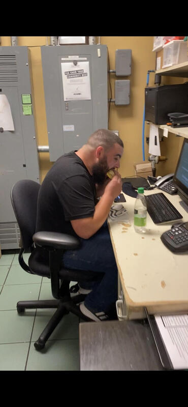 A man eating Starbucks food at a desk.