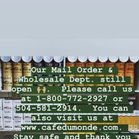 Screenshot of a Facebook post by Café Du Monde that informs patrons that their mail order and whole department are still open. 