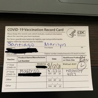 This is a picture taken of a person's vaccine card. Any personal information has been blurred out. 
