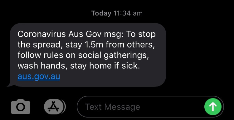 A text from the Australia Government stating, "Coronavirus Aus Gov msg: To stop the spread, stay 1.5m away from others, follow rules on social gatherings, wash hands, stay home when sick. aus.gov.au."
