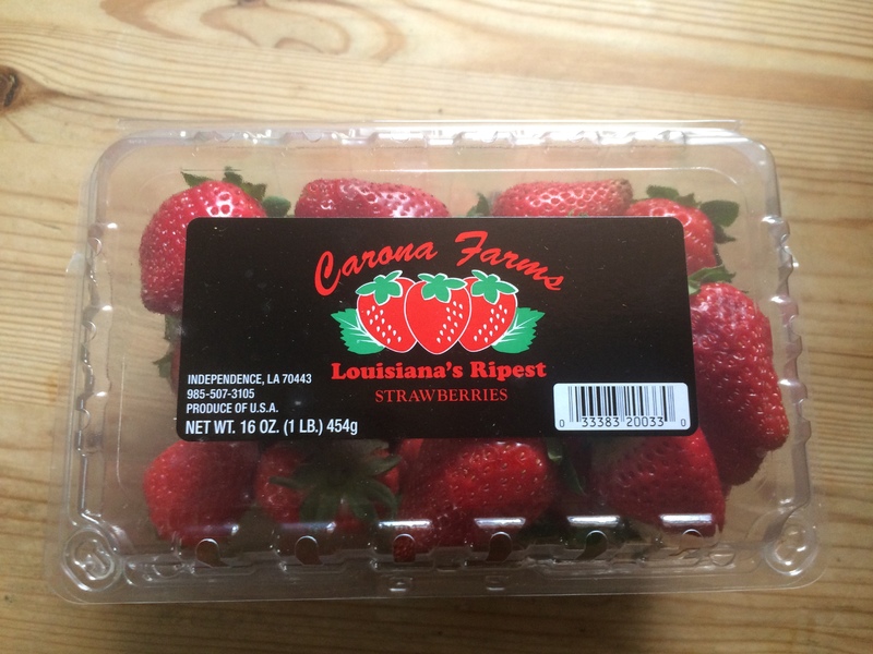 a plastic container of strawberries