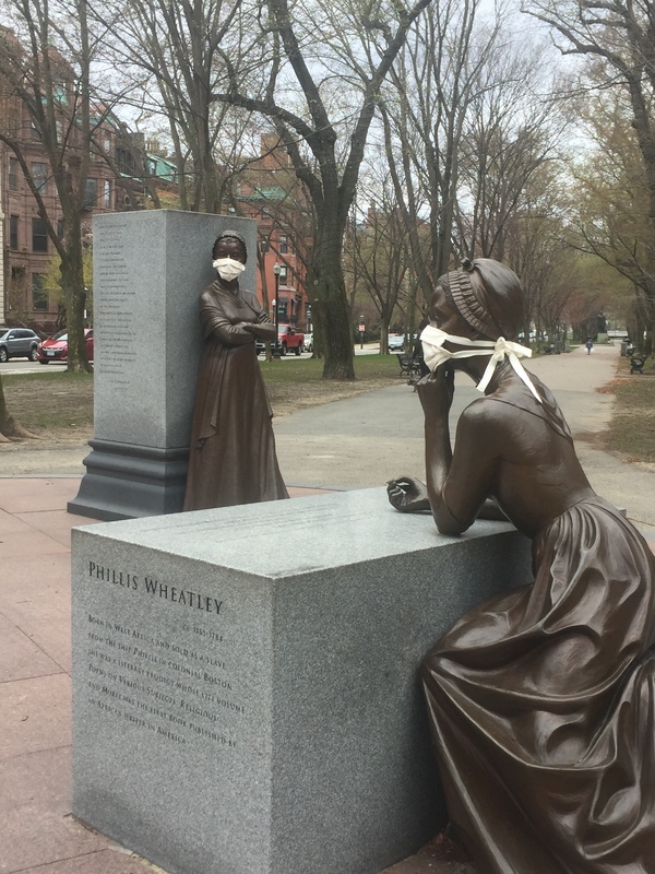 A bronze statue with a mask on.