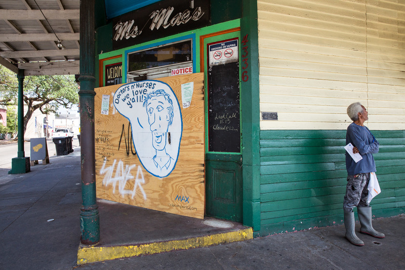A man waiting for a bus in front of Ms. Mae's Bar in New Orleans.