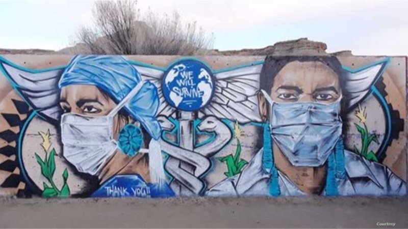This is a mural on a wall depicting two healthcare workers wearing face masks, in between which the caduceus symbol and a globe can be seen. The words "We Will Survive" are written on the globe.