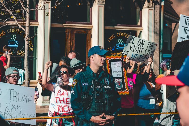 This is a picture of a police officer who is standing guard during a protest against President Donald Trump.