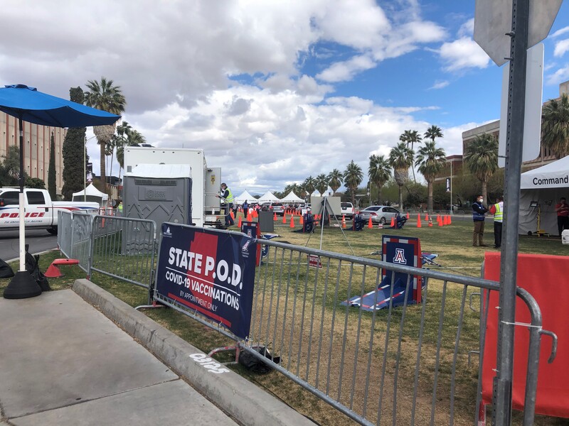 This is a picture of a vaccination site set up at the University of Arizona. Temporary fences and traffic cones help those in line adhere to social distancing protocols.
