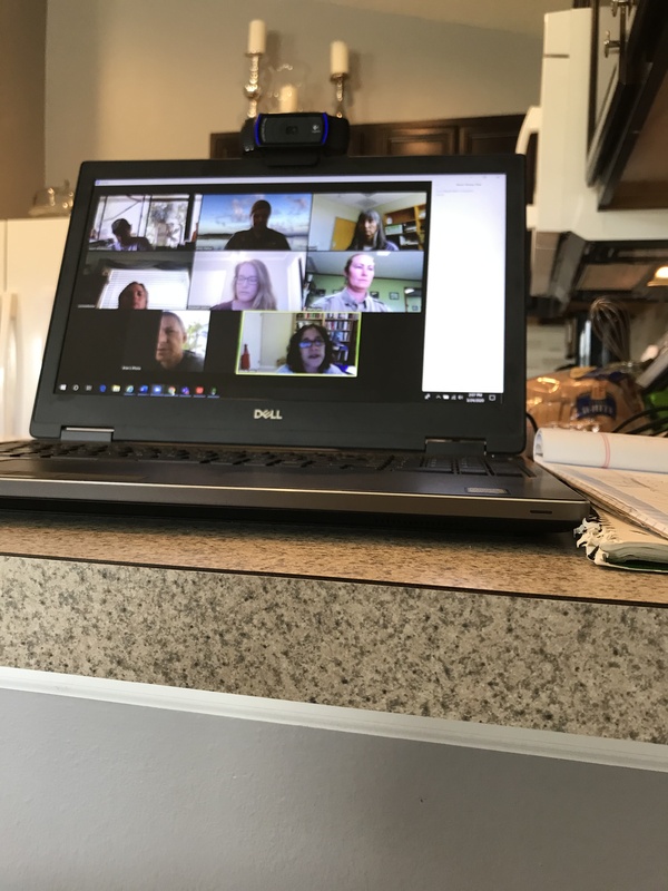 This is a picture of a Dell laptop resting on a table with a video call opened on its screen.