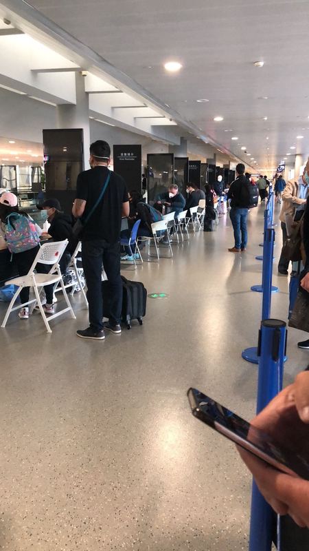 People waiting in line to be Covid tested at an airport.