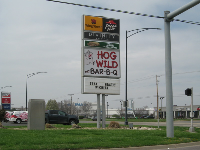 Image of business signs, the bottom one says stay healthy, Wichita.