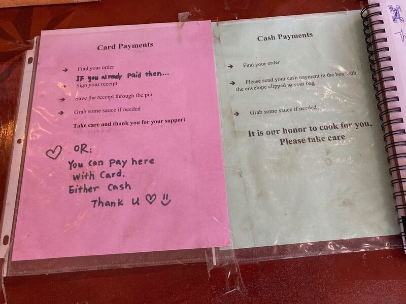 This is a picture taken of two slips of paper, each explaining how to purchase food with cash or card.