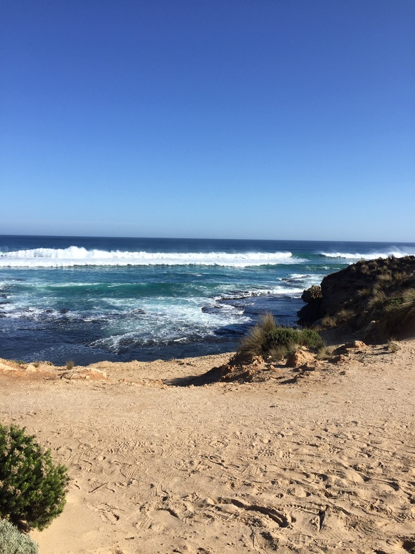 This is a picture taken of waves rolling onto a sandy beach.