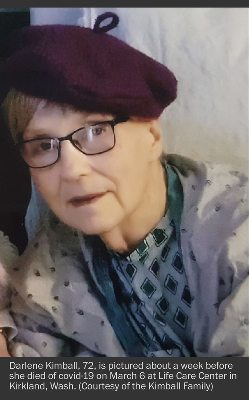 A woman is wearing a purple beret with black glasses on. She is wearing a white coat with a green shirt with diamonds on it.