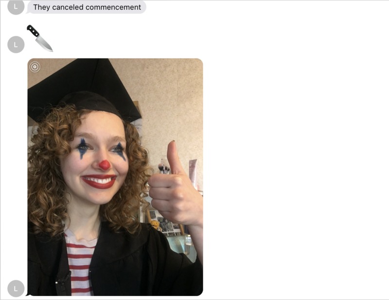 A person is wearing a graduation cap and gown and has on clown makeup. They are giving a thumbs up.