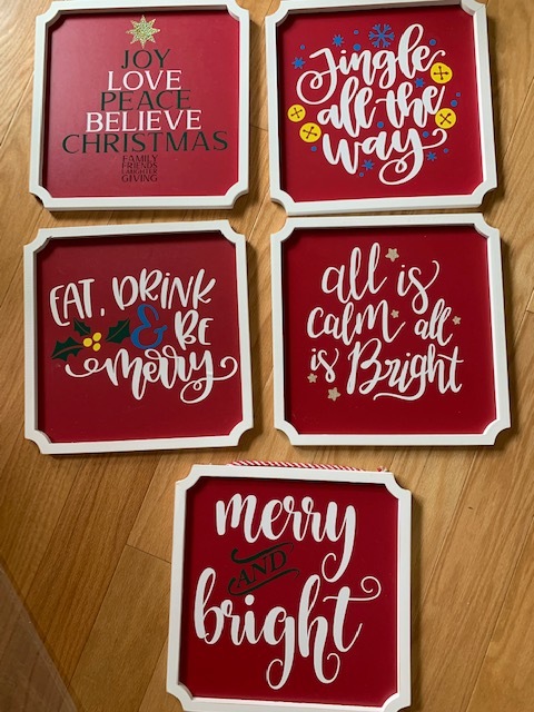 Five signs reading Joy Love Peace Believe Christmas, Jingle All the Way, Eat Drink and Be Merry, All is Calm and Bright, and Merry and Bright.