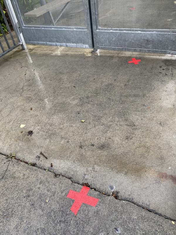 Two red X's on the ground six feet apart.