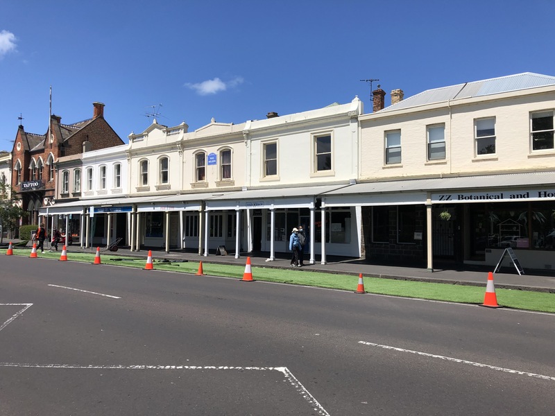 Picture of workers unfurling artificial turf in front of a hospital in Melbourne, Australia.