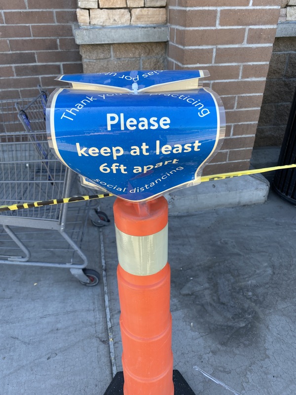 A blue sign on an orange pole.