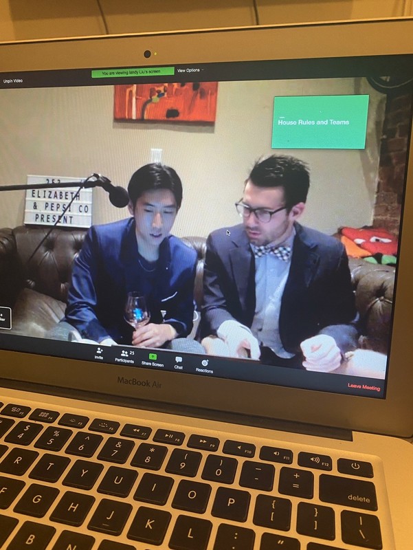 A laptop shows a Zoom meeting on the screen.