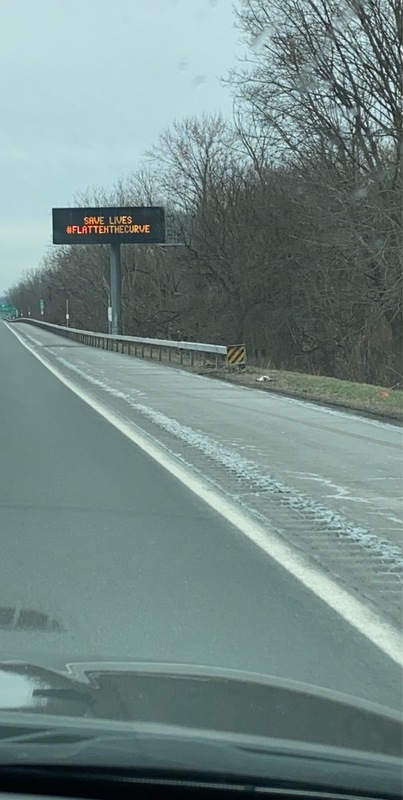 A sign reads "save lives #flattenthecurve". 