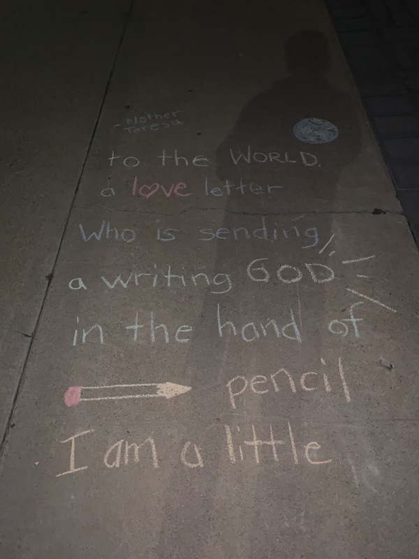 The words "I am a little pencil in the hands of a writing God, who is sending a love letter to the world. -Mother Teresa" written on a sidewalk in chalk.