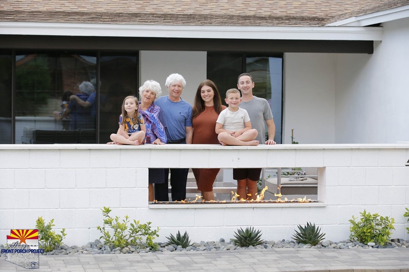 A family posing for a picture in front of a house.