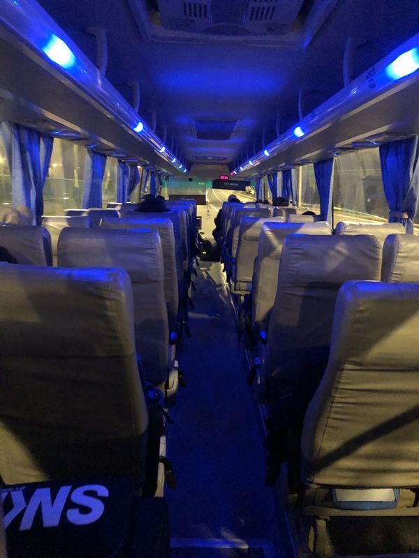 People sitting one person to a row on a bus.