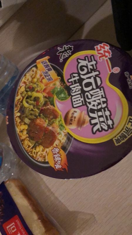 Instant noodles next to two bottles of water.