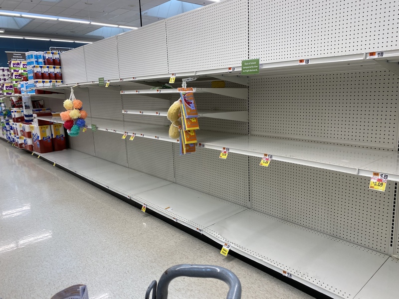 Empty row of shelves in an aisle at a supermarket.