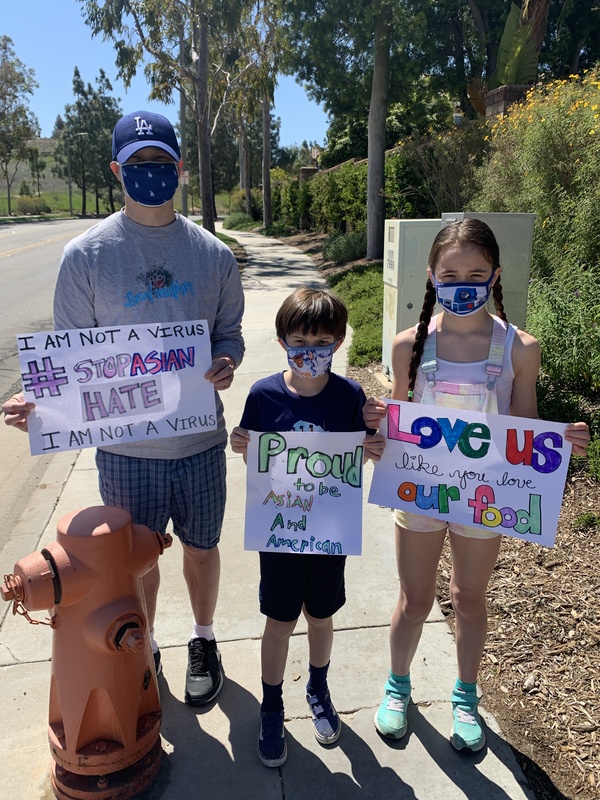This is a picture of an Asian man and two children holding signs that urge the reader to help combat attitudes of Asian hate in wake of the COVID-19 Pandemic.