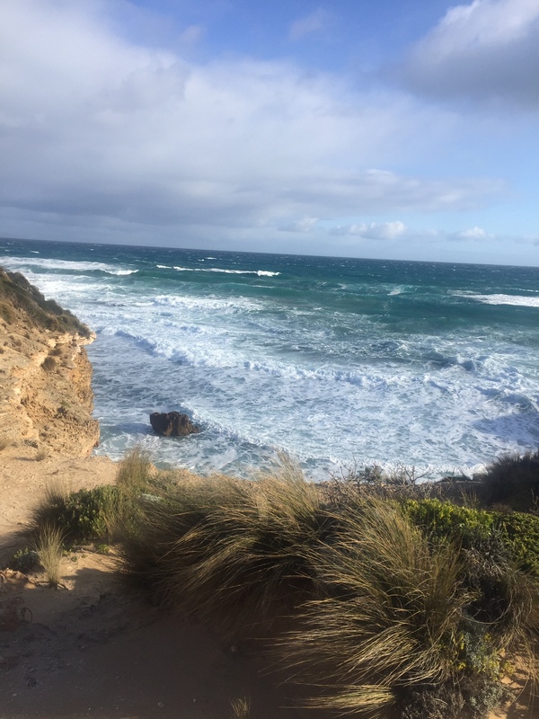 This is a picture of ocean waves approaching a small cove at a beach.