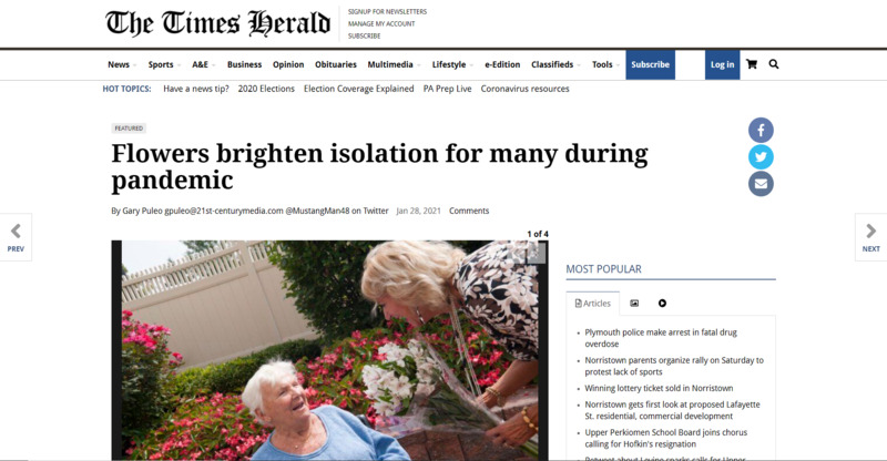 Screenshot of The Times Herald web article. Image of woman handing flowers to elderly woman. Headline reads, "Flowers brighten isolation for many during pandemic".