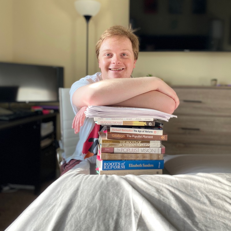 A person leaning on a stack of books.