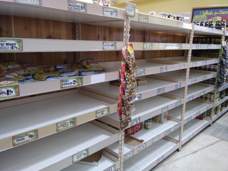 A row of stacked shelves that is barely stocked.