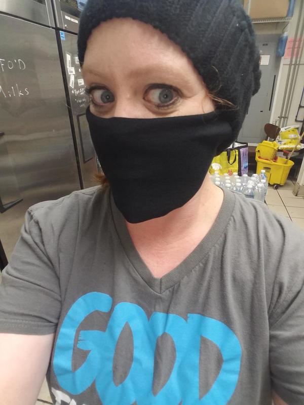 A person posing for a picture with a mask on.