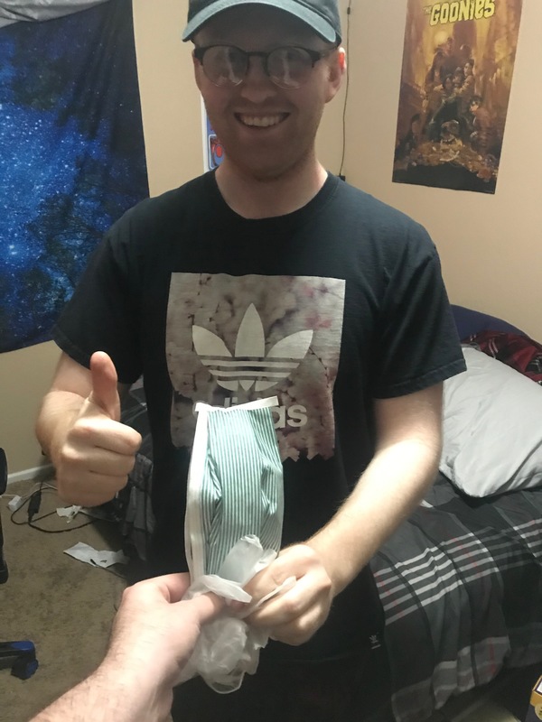 A person handing someone a pair of gloves and a mask. 