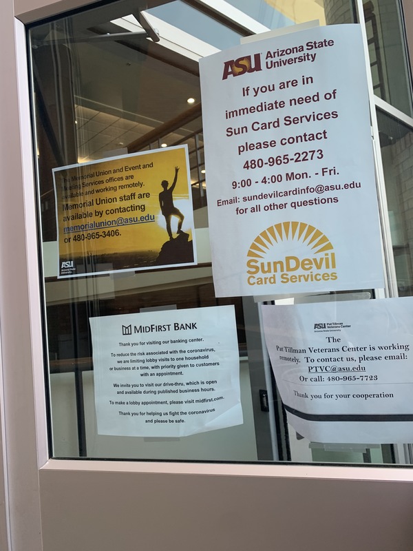 Multiple signs on a door window.