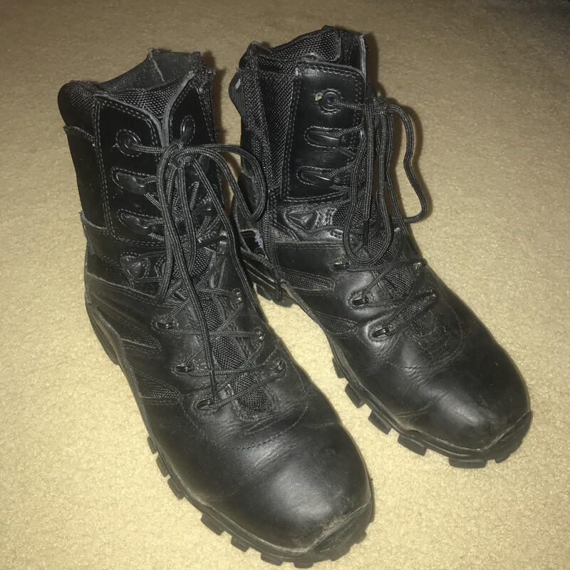 This is a picture of a pair of black boots resting on a carpet floor. 