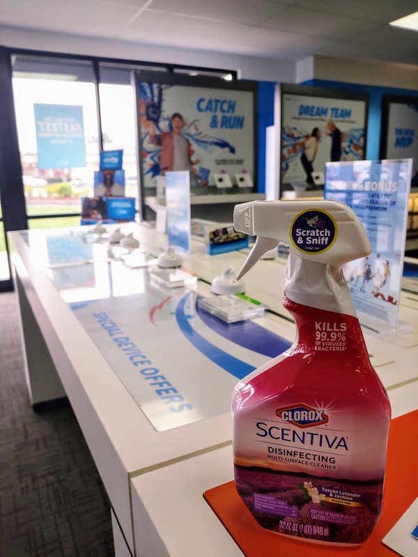 A bottle of clorox that is on top of a display case for phones that is empty.