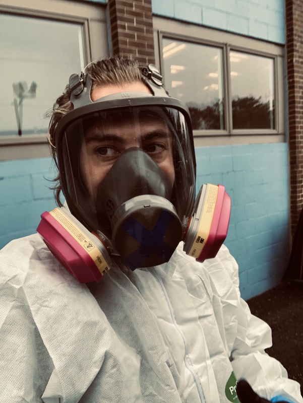 A person is wearing a hazmat suit and has a mask that is covering their face completely.