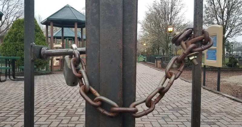 A gate that is locked surrounding a playground.
