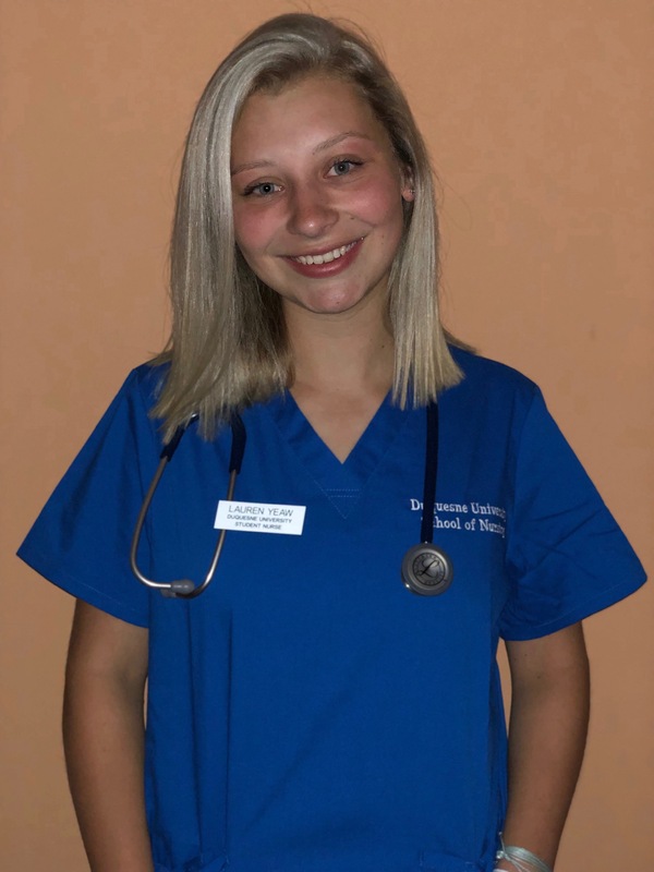Female nurse dressed in blue scrubs with stethoscope.